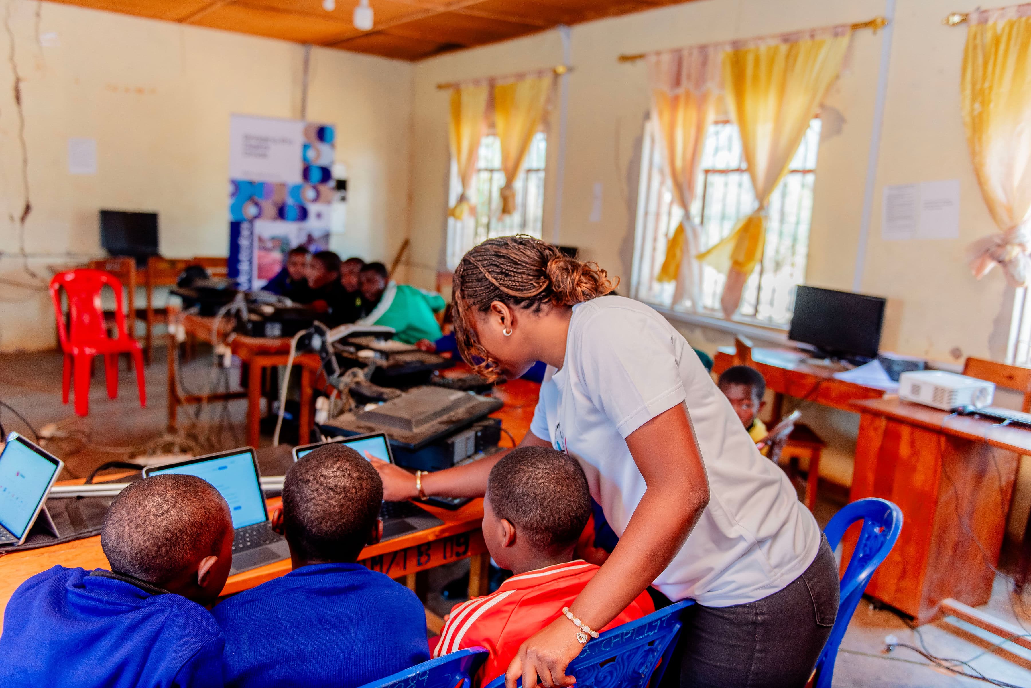 An instructor helping students at their classroom table